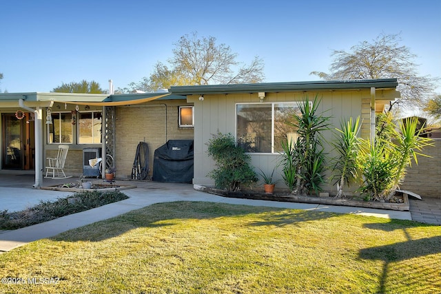 view of front of property featuring a front yard and a patio