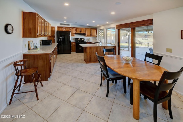 dining space featuring sink and light tile patterned floors