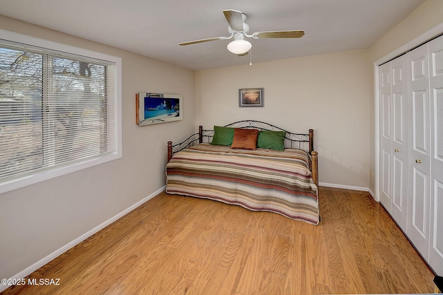 bedroom with ceiling fan, light hardwood / wood-style flooring, and a closet