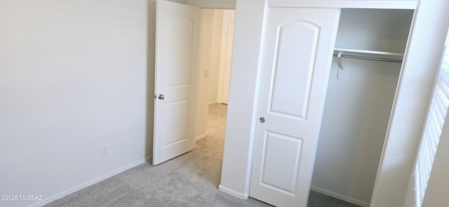 unfurnished bedroom featuring light colored carpet and a closet