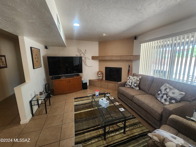 tiled living room with a fireplace and a textured ceiling