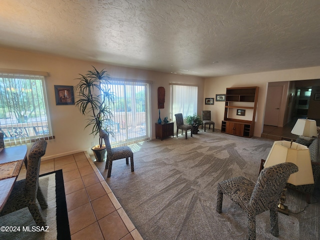 living room featuring tile patterned flooring, a textured ceiling, and plenty of natural light