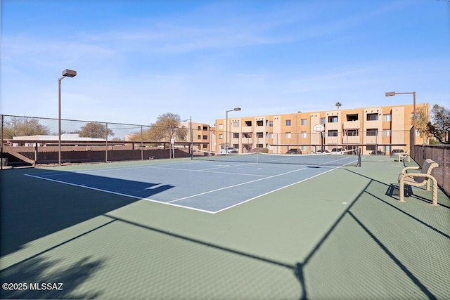 view of tennis court featuring basketball hoop