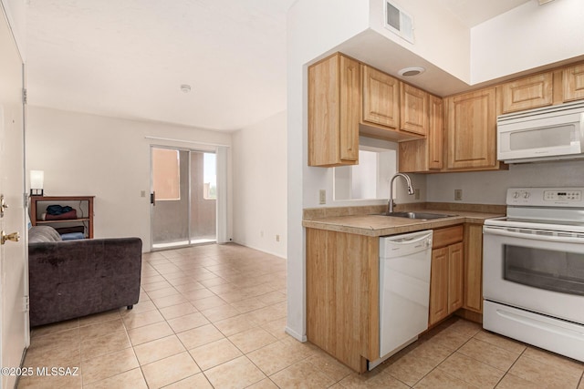 kitchen with light brown cabinetry, sink, light tile patterned floors, and white appliances