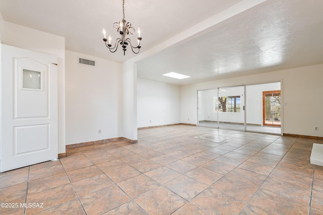 unfurnished room with a chandelier