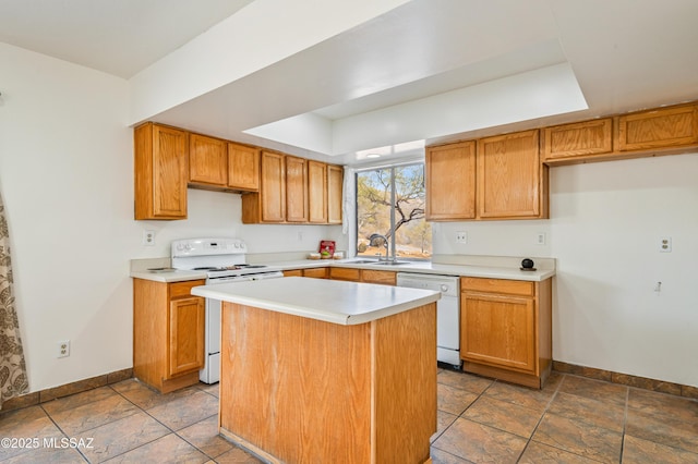 kitchen featuring a raised ceiling, a kitchen island, sink, and white appliances