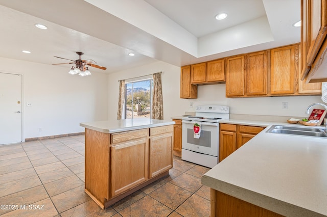 kitchen featuring sink, a tray ceiling, a kitchen island, electric stove, and ceiling fan