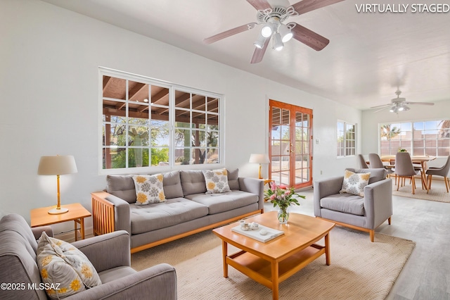 living room with french doors, ceiling fan, and light hardwood / wood-style floors