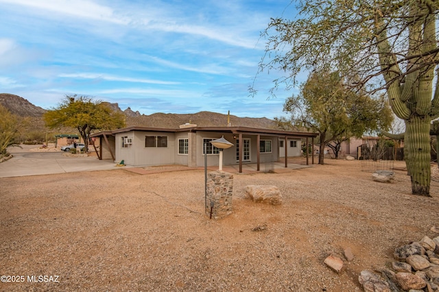 rear view of property with a mountain view and a patio