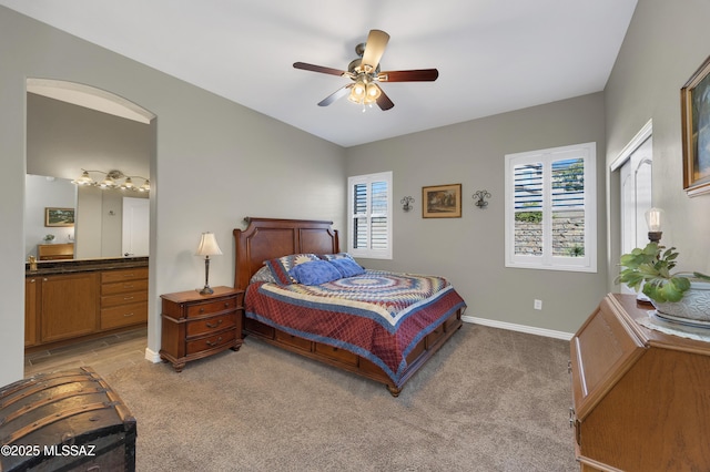 bedroom featuring ceiling fan, light colored carpet, and multiple windows