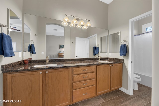 full bathroom with toilet, ceiling fan, shower / bath combo, and vanity