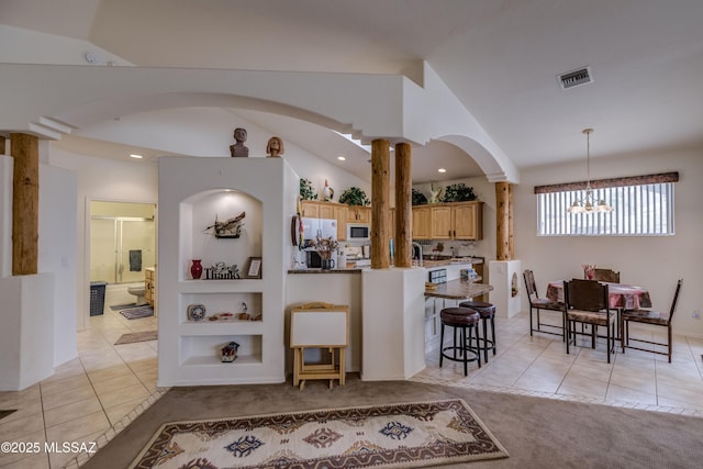 kitchen with white appliances, built in shelves, a chandelier, and lofted ceiling