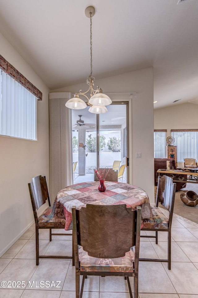 dining space featuring an inviting chandelier, vaulted ceiling, and light tile patterned floors