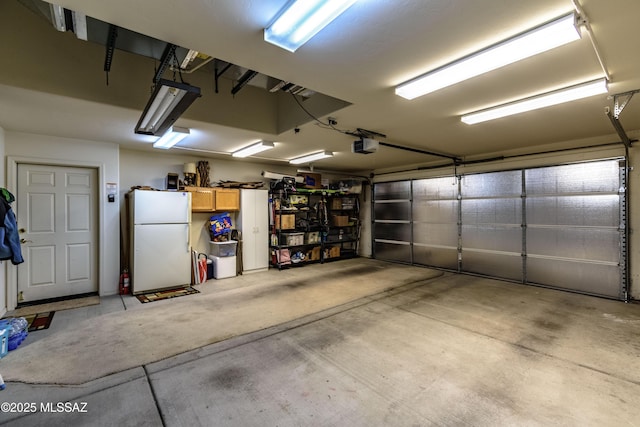 garage with white fridge and a garage door opener