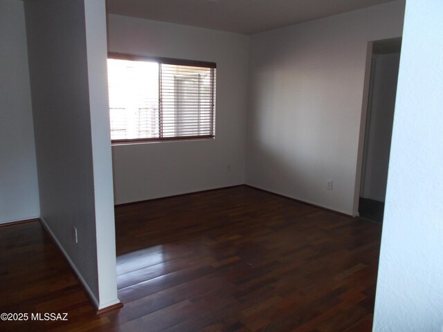 spare room with dark hardwood / wood-style flooring