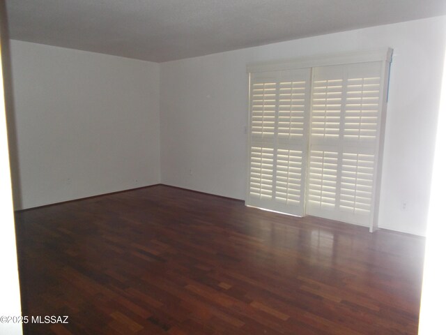 spare room with dark wood-type flooring and a textured ceiling