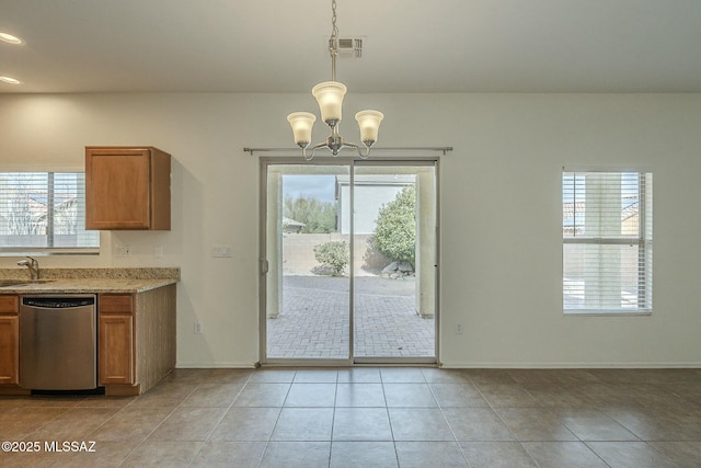 kitchen featuring light tile patterned flooring, stainless steel dishwasher, plenty of natural light, and decorative light fixtures