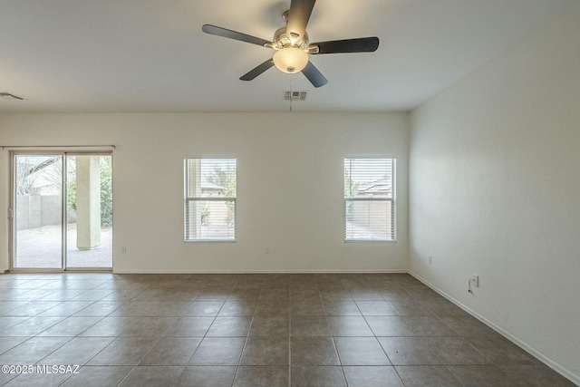 tiled spare room with ceiling fan