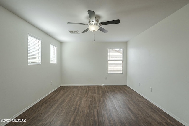 unfurnished room with dark hardwood / wood-style flooring, plenty of natural light, and ceiling fan