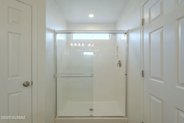 bathroom featuring a shower with door