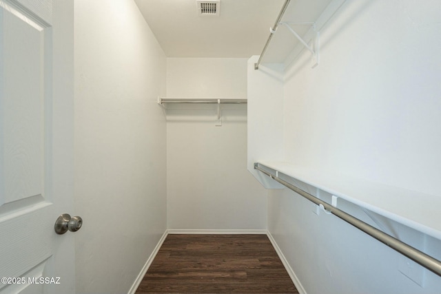 walk in closet with dark wood-type flooring