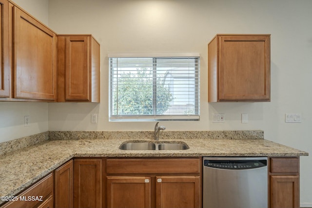 kitchen with light stone counters, stainless steel dishwasher, and sink