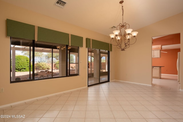 empty room featuring a notable chandelier, light tile patterned floors, and lofted ceiling