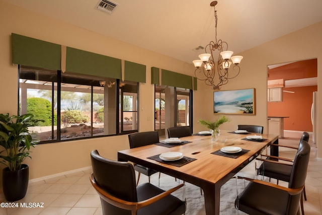 tiled dining space with a chandelier and vaulted ceiling