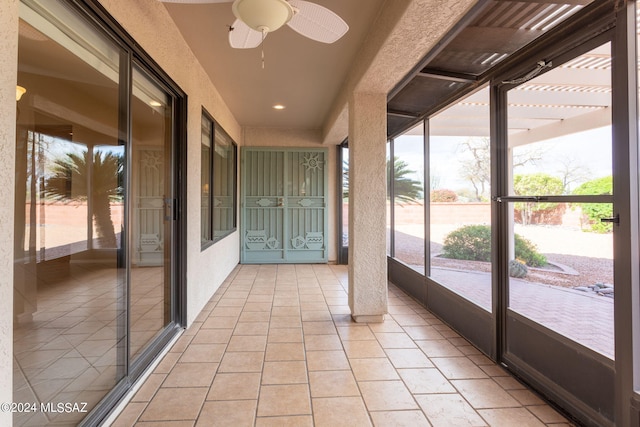 unfurnished sunroom with ceiling fan