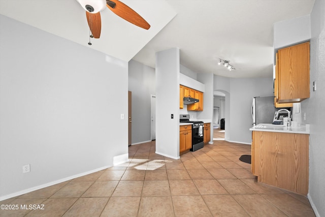 kitchen featuring black gas stove, light tile patterned floors, ceiling fan, and sink