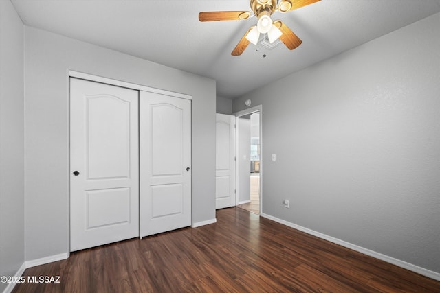 unfurnished bedroom with dark hardwood / wood-style flooring, a closet, and ceiling fan