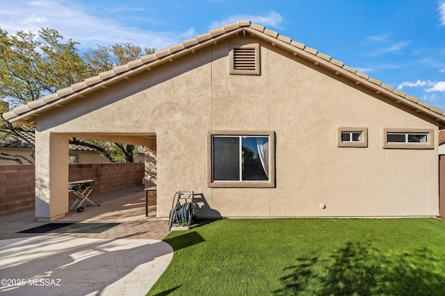 back of property featuring a yard and a patio area