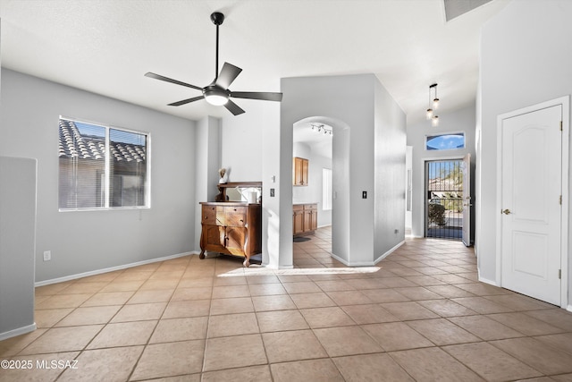 tiled empty room with a towering ceiling and ceiling fan