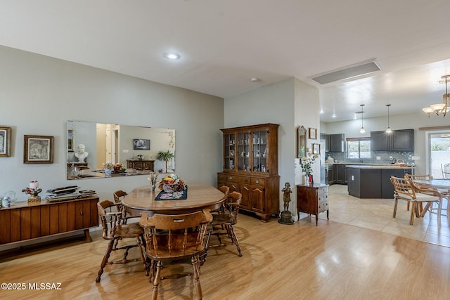 dining area with a notable chandelier and light hardwood / wood-style flooring