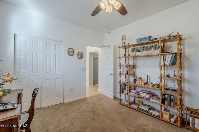 carpeted home office featuring ceiling fan