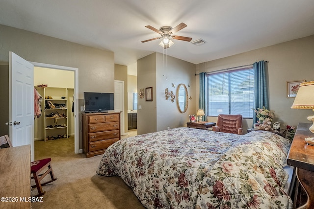 carpeted bedroom featuring ensuite bath, ceiling fan, a closet, and a spacious closet