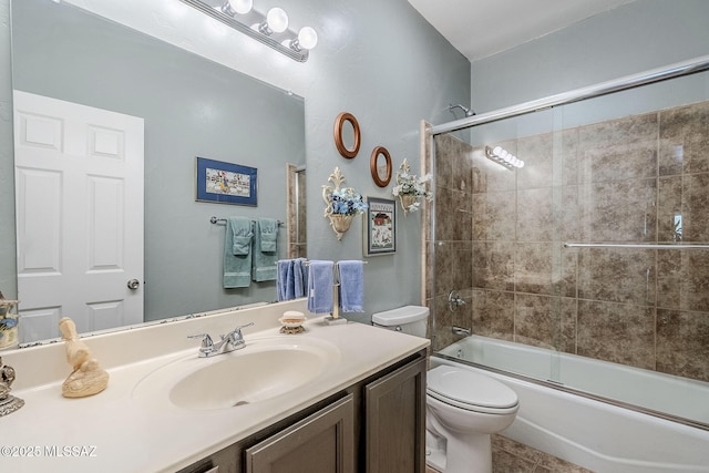 full bathroom with tile patterned floors, vanity, toilet, and bath / shower combo with glass door