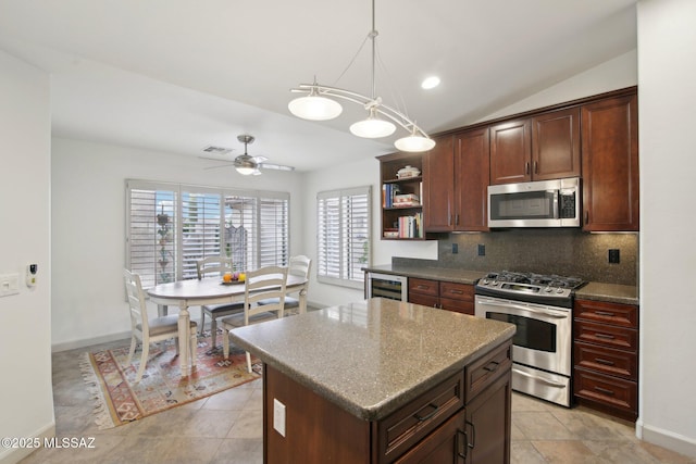 kitchen featuring vaulted ceiling, a kitchen island, pendant lighting, backsplash, and stainless steel appliances