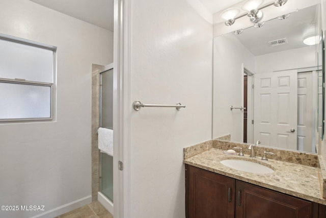 bathroom featuring vanity, an enclosed shower, and tile patterned flooring