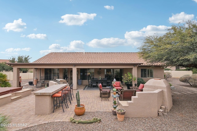 back of house featuring an outdoor bar, an outdoor hangout area, and a patio area