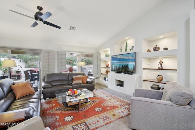 living room featuring built in shelves, lofted ceiling, and a healthy amount of sunlight