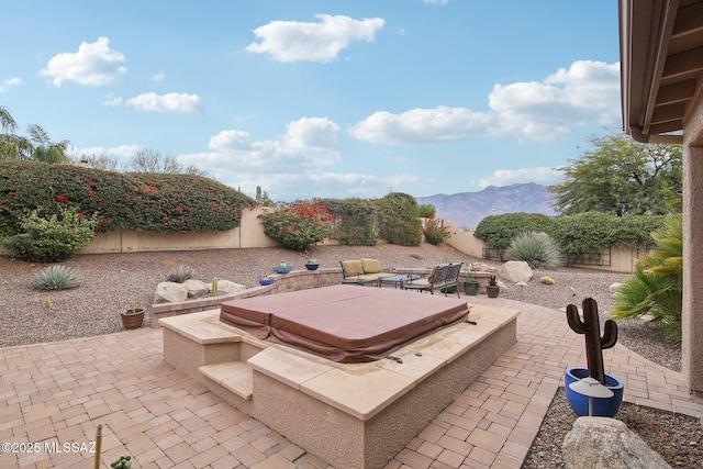 view of patio featuring a mountain view and a covered hot tub