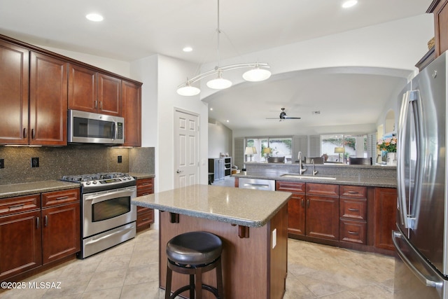 kitchen featuring vaulted ceiling, appliances with stainless steel finishes, and a breakfast bar