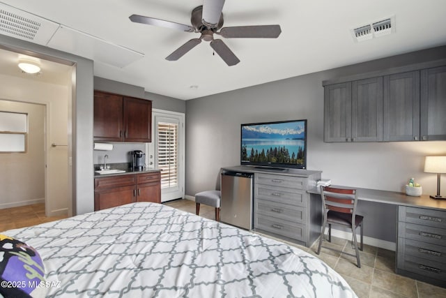 bedroom featuring sink, ceiling fan, refrigerator, and built in desk