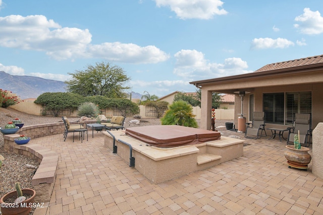 view of patio with a mountain view and a covered hot tub