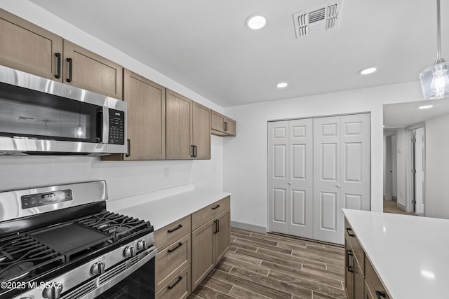 kitchen with hanging light fixtures and stainless steel appliances