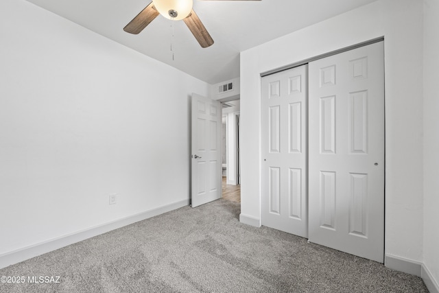 unfurnished bedroom featuring ceiling fan, a closet, and light colored carpet