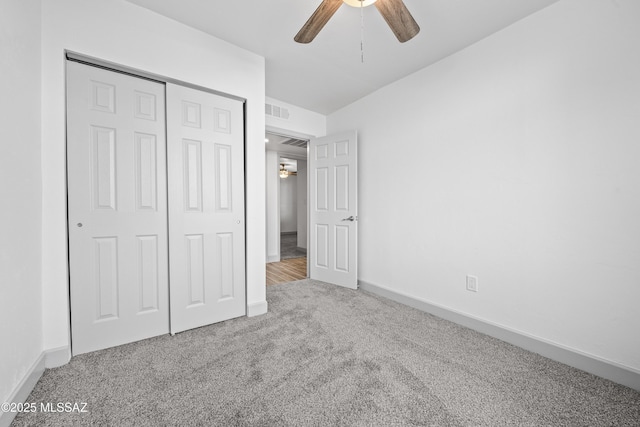 unfurnished bedroom with ceiling fan, light carpet, and a closet