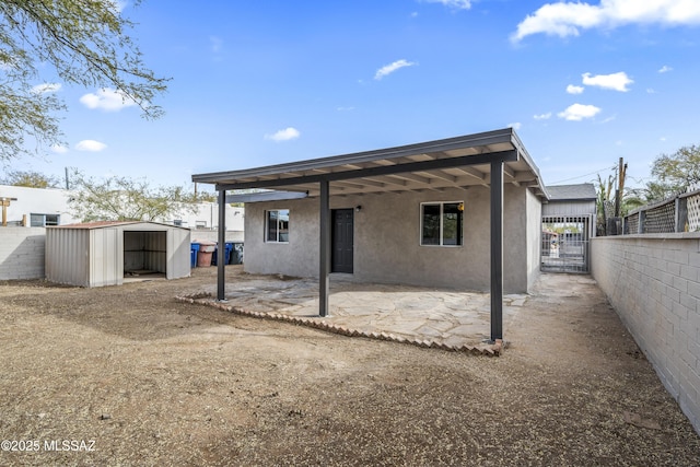 rear view of house with a patio area and a shed