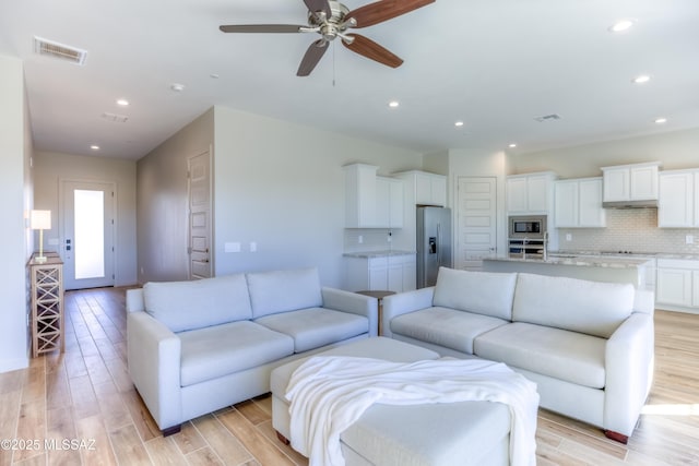 living room with ceiling fan and light hardwood / wood-style floors